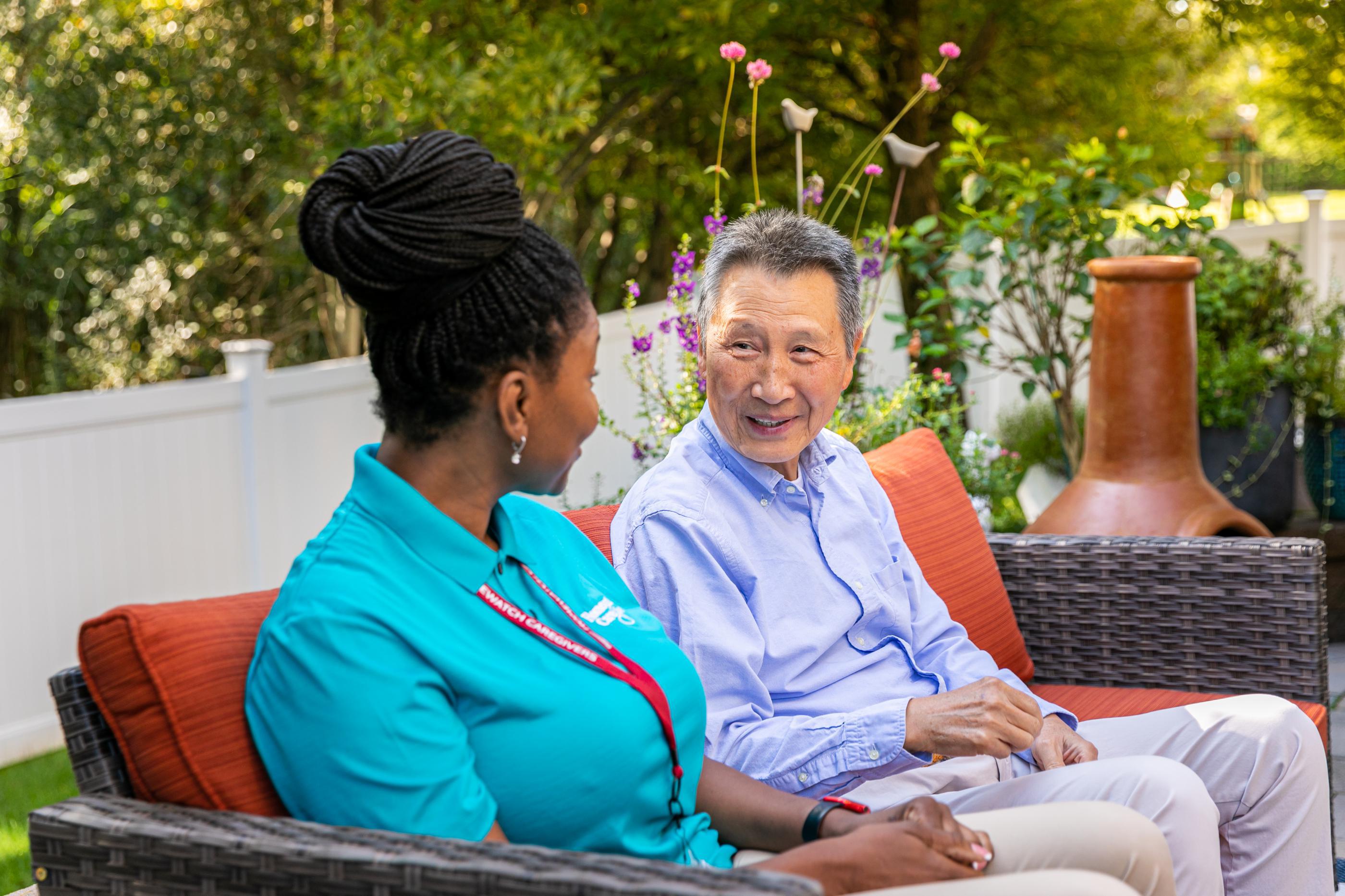 women and man sitting outside on couch 