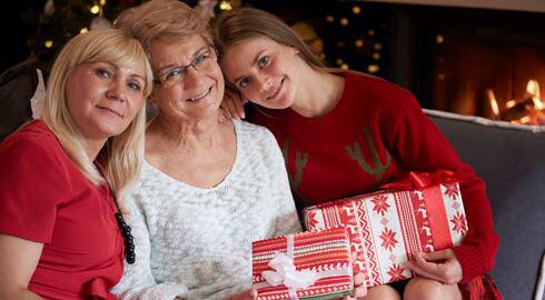 Holiday Times Three women on a sofa with Christmas presents