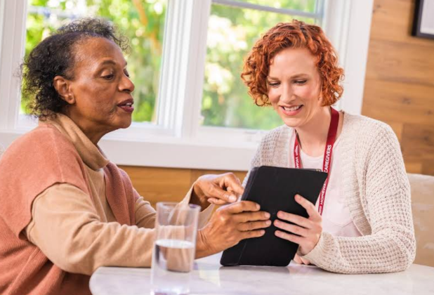 women smiling and pointing at tablet