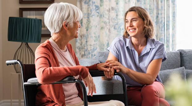 woman holding woman's hand in wheelchair