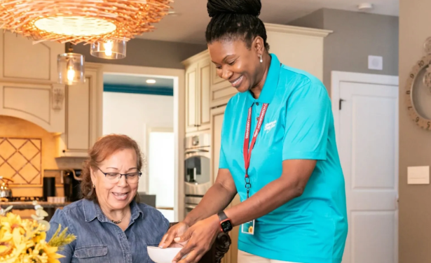 caregiver handing woman bowl