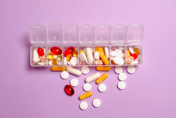 open pills case with pills spilling out