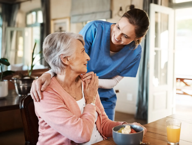 caregiver with hands on woman's shoulders smiling