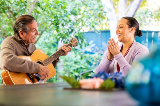 man playing guitar to woman
