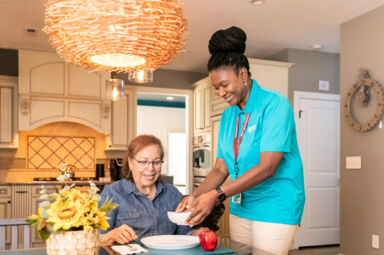 woman setting food down in front of another woman