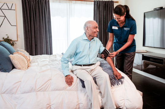 caregiver taking man's blood pressure