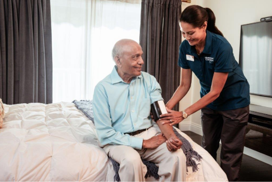 caregiver taking mans blood pressure