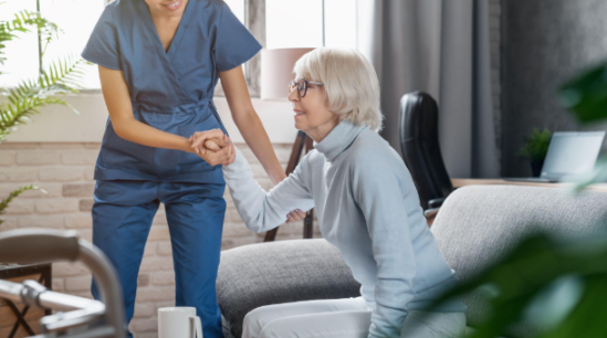 caregiver helping woman off couch