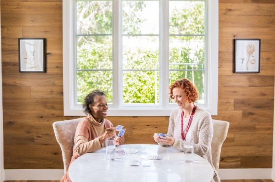 two woman playing cards at table