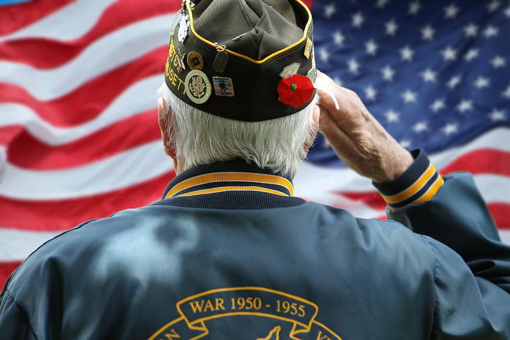 veteran turned towards the American flag with hand to forehead ready to salute