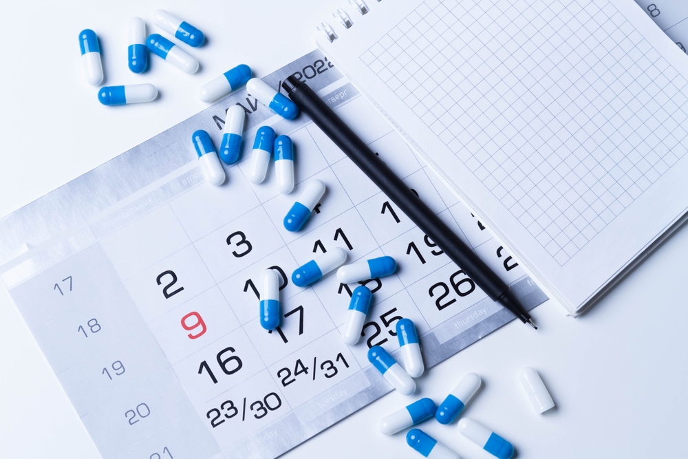 Pills spilled on top of a calendar