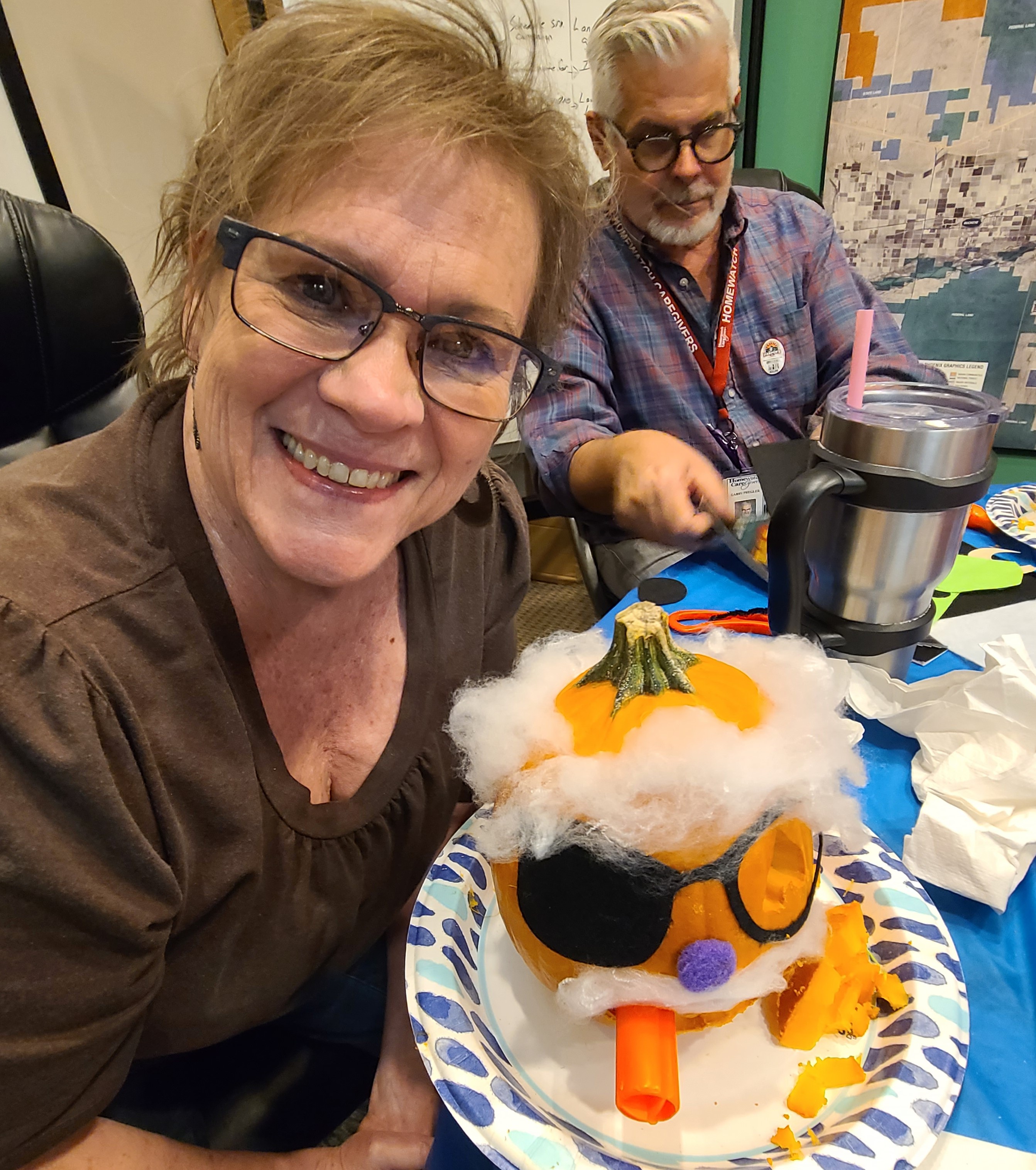 a woman showing a pumpkin she decorated