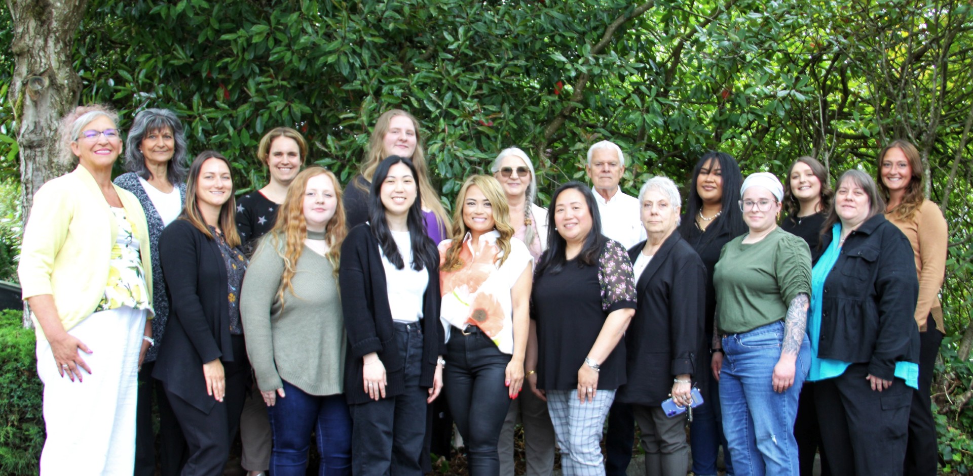 team photo in front of green trees