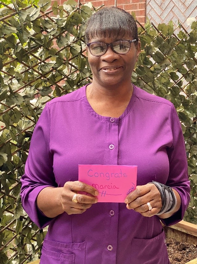 headshot of Marcia in front of fence