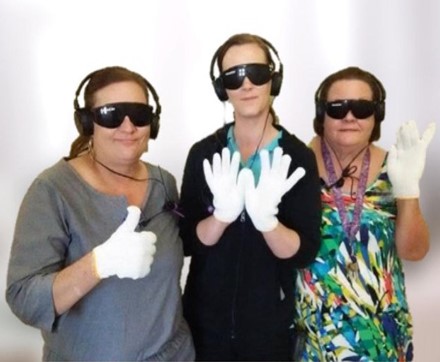 three women wearing gloves, headphones, and dark sunglasses