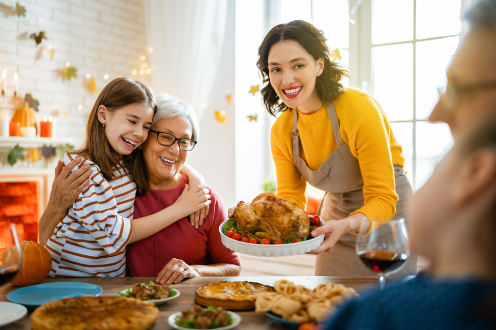 multi-generational family gathered around the table with thanksgiving foods