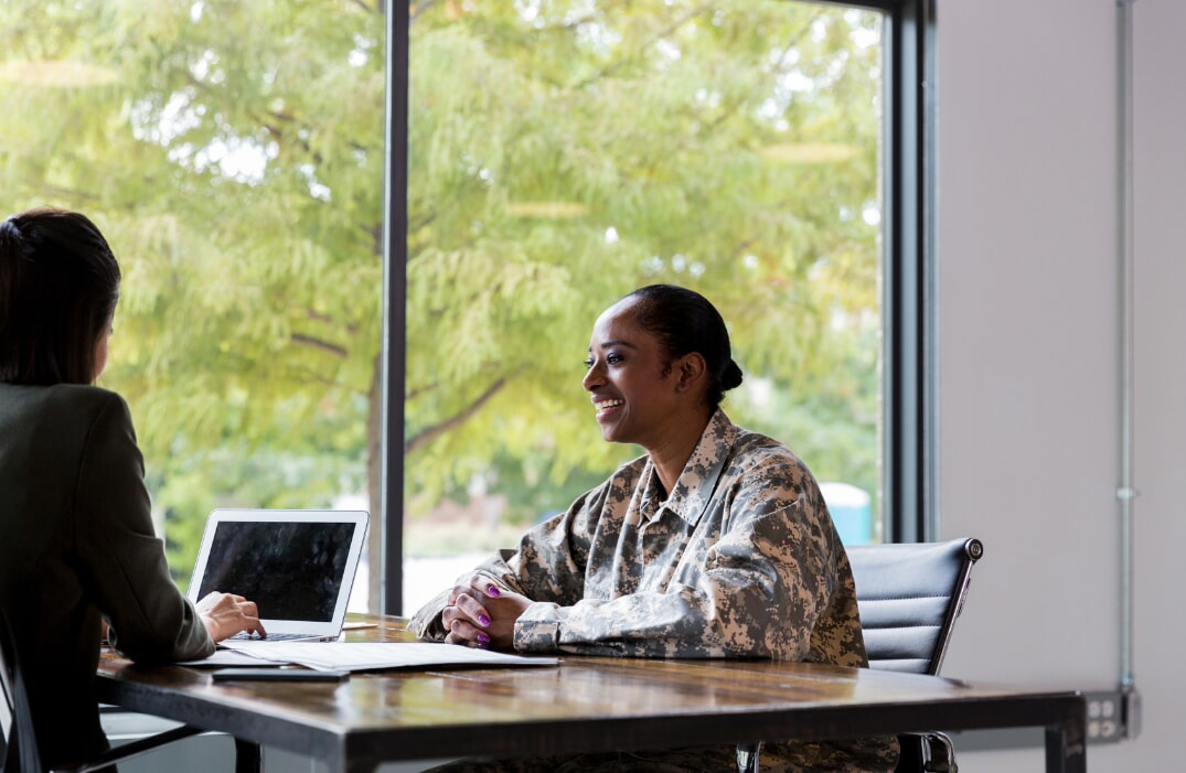 Veteran talking with woman in front of window