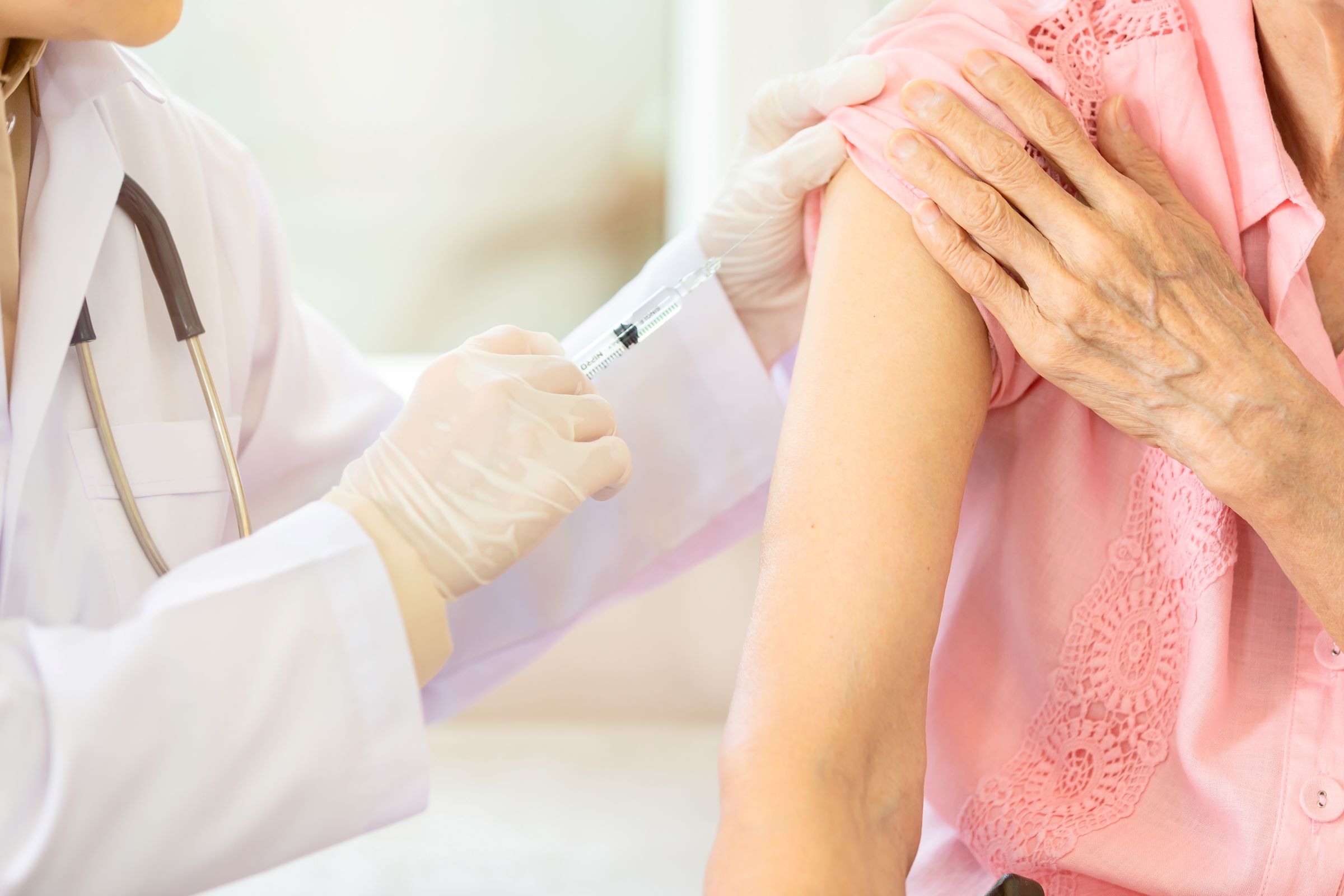 doctor administering shot in arm of woman